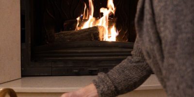 a man standing in front of a fire oven