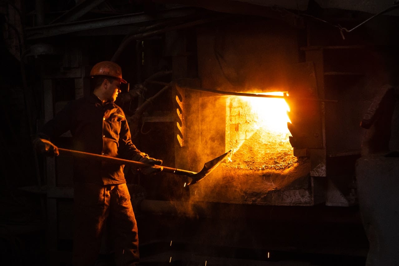 a man standing in front of a fire oven